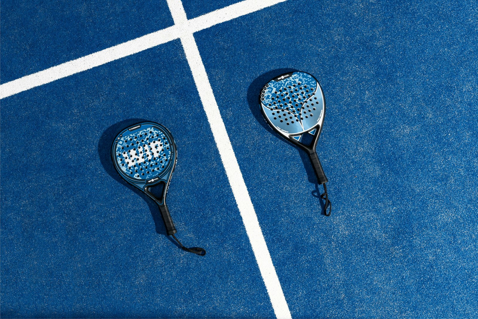 Padel rackets and balls laid out on a court